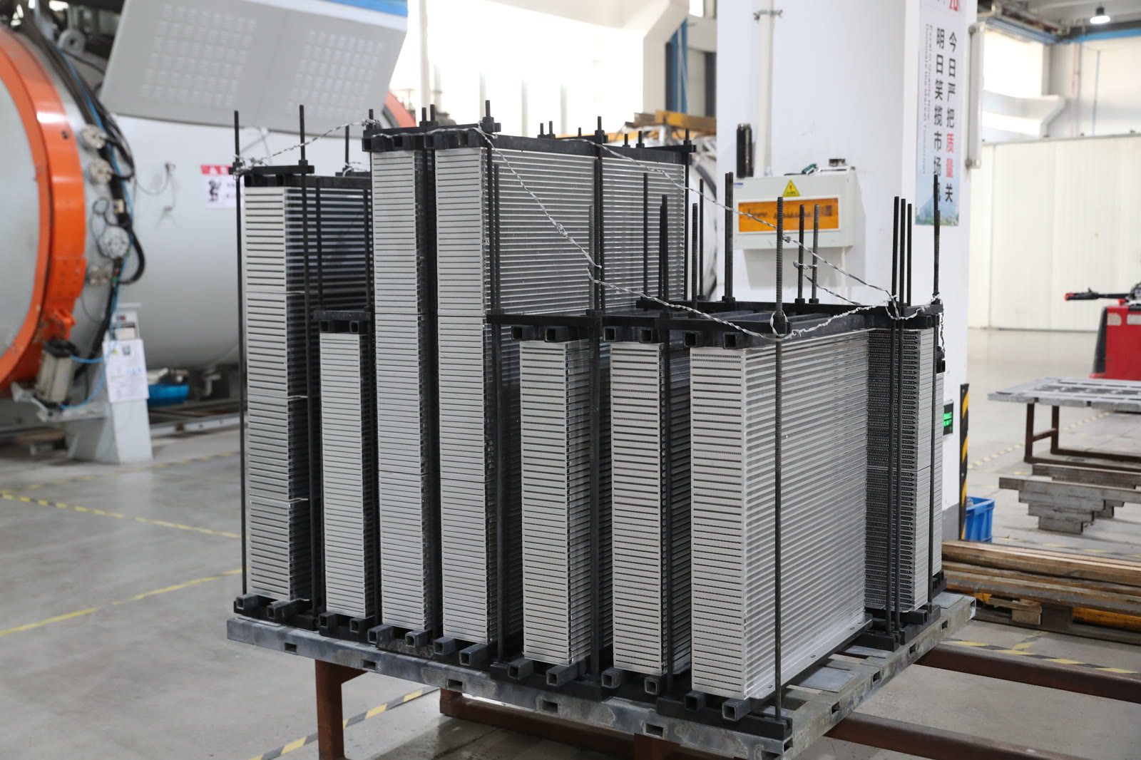 Bar-plate cooler cores stacked in fixtures, prepared for vacuum brazing