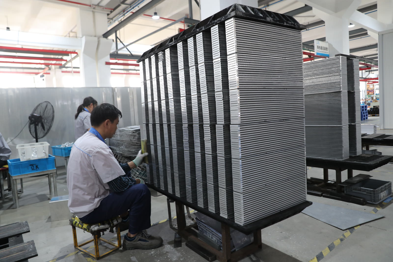 Tube-fin core assembly area with stacked aluminum cores prior to brazing